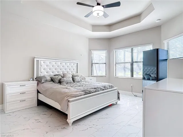 a spacious bedroom with a bed and a large window