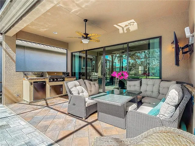 a living room with furniture a flat screen tv and a floor to ceiling window
