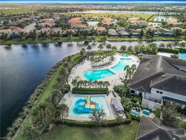 an aerial view of residential houses with outdoor space and lake view