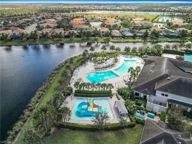 an aerial view of residential houses with outdoor space and lake view