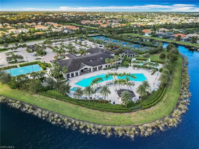 an aerial view of a house with a swimming pool a yard and lake view