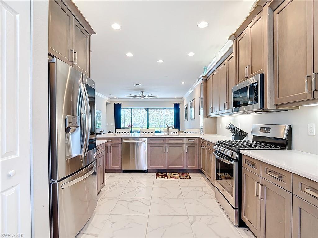 4310 Aurora Street Naples, FL 34119 - Photo 9 of 50 a kitchen with a refrigerator and a stove top oven