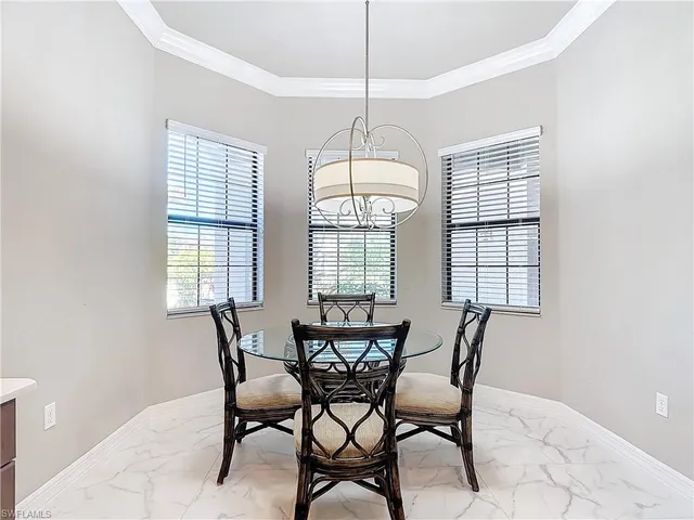 a dining room with furniture a chandelier and window