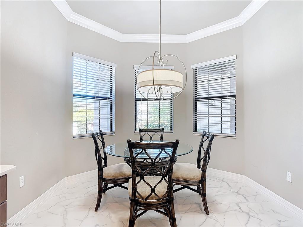 4310 Aurora Street Naples, FL 34119 - Photo 10 of 50 a dining room with furniture a chandelier and window