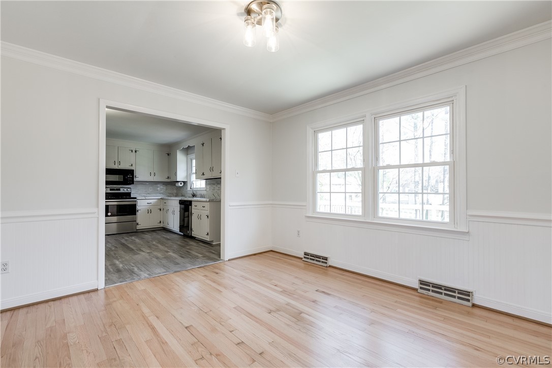 13007 Buckland Road Chester, VA 23831 - Photo 12 of 44 an empty room with wooden floor and a kitchen