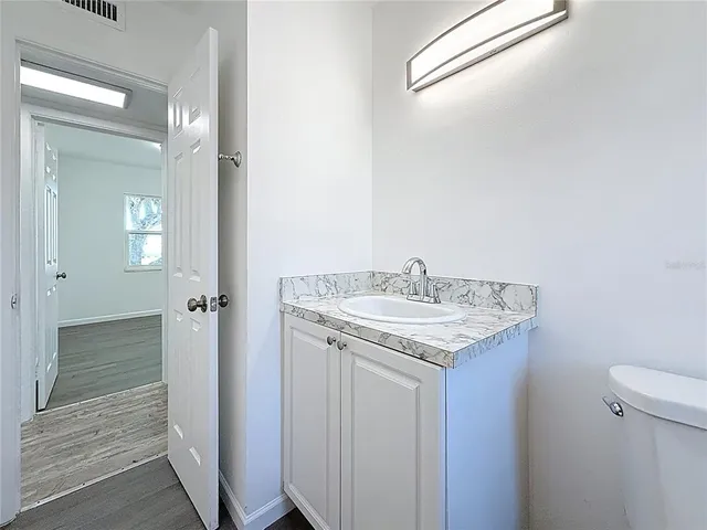 a bathroom with a granite countertop sink and a mirror