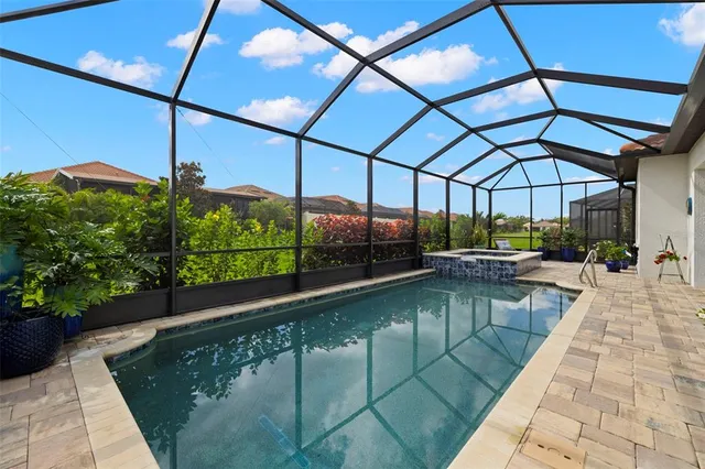 an aerial view of a pool a yard patio swimming pool and outdoor seating