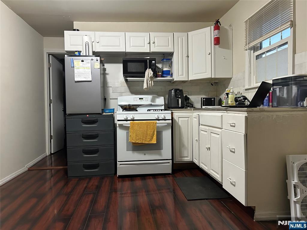 40 Poplar Street Lodi, NJ 07644 - Photo 2 of 16 a kitchen with cabinets appliances and wooden floor