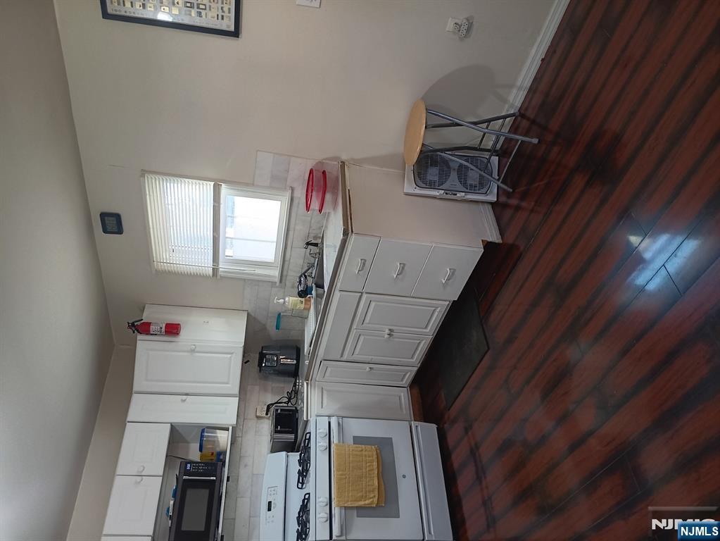 40 Poplar Street Lodi, NJ 07644 - Photo 6 of 16 a kitchen with a sink a stove cabinets and wooden floor