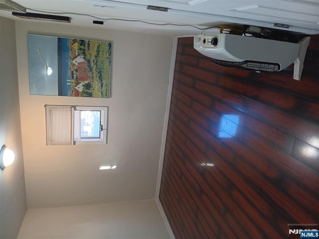 40 Poplar Street Lodi, NJ 07644 - Photo 7 of 16 an empty room with wooden floor and windows
