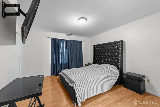 a bedroom with a bed and wooden floor