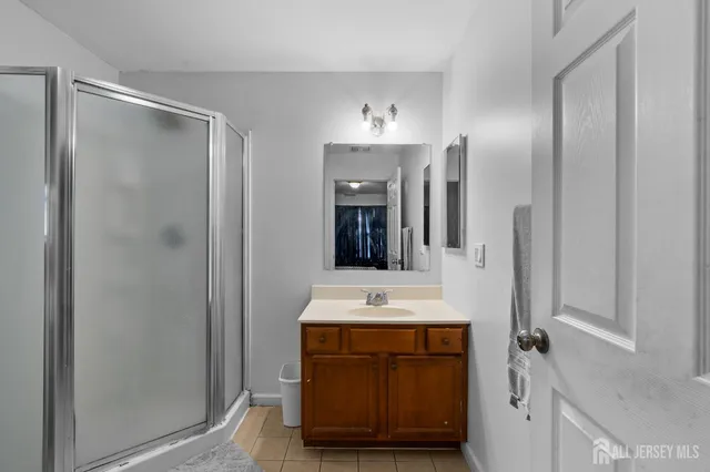 a bathroom with a shower sink and mirror