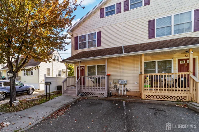 a view of a house with a wooden fence and large trees
