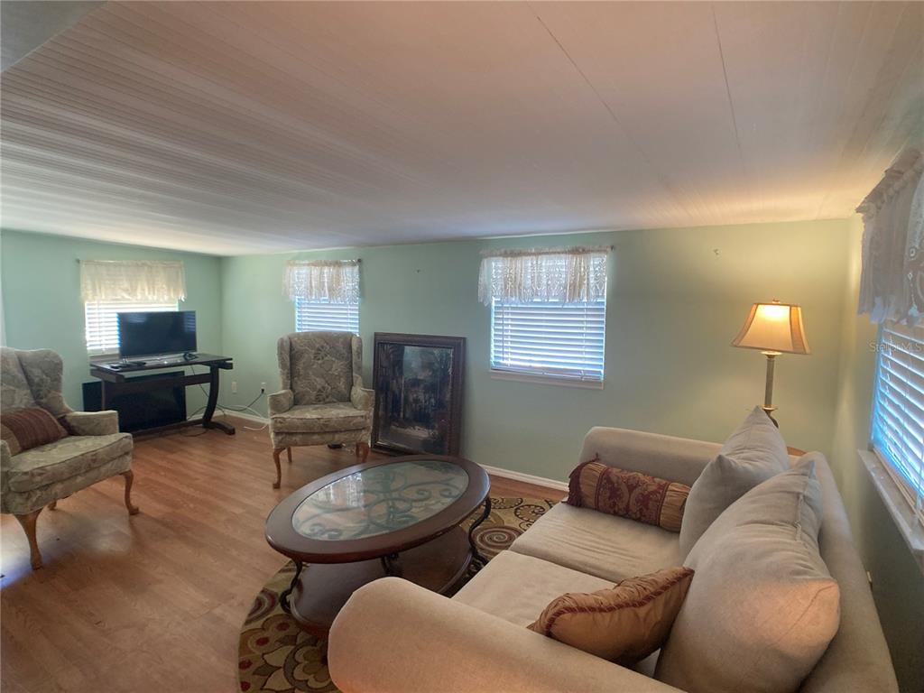 1710 7th Street Southwest, Unit 44 Ruskin, FL 33570 - Photo 11 of 34 a living room with furniture a lamp a window and a flat screen tv