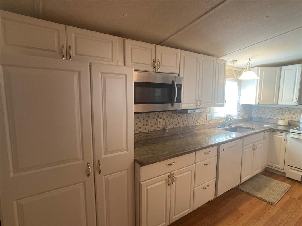 1710 7th Street Southwest, Unit 44 Ruskin, FL 33570 - Photo 15 of 34 a kitchen with stainless steel appliances white cabinets and a granite counter tops