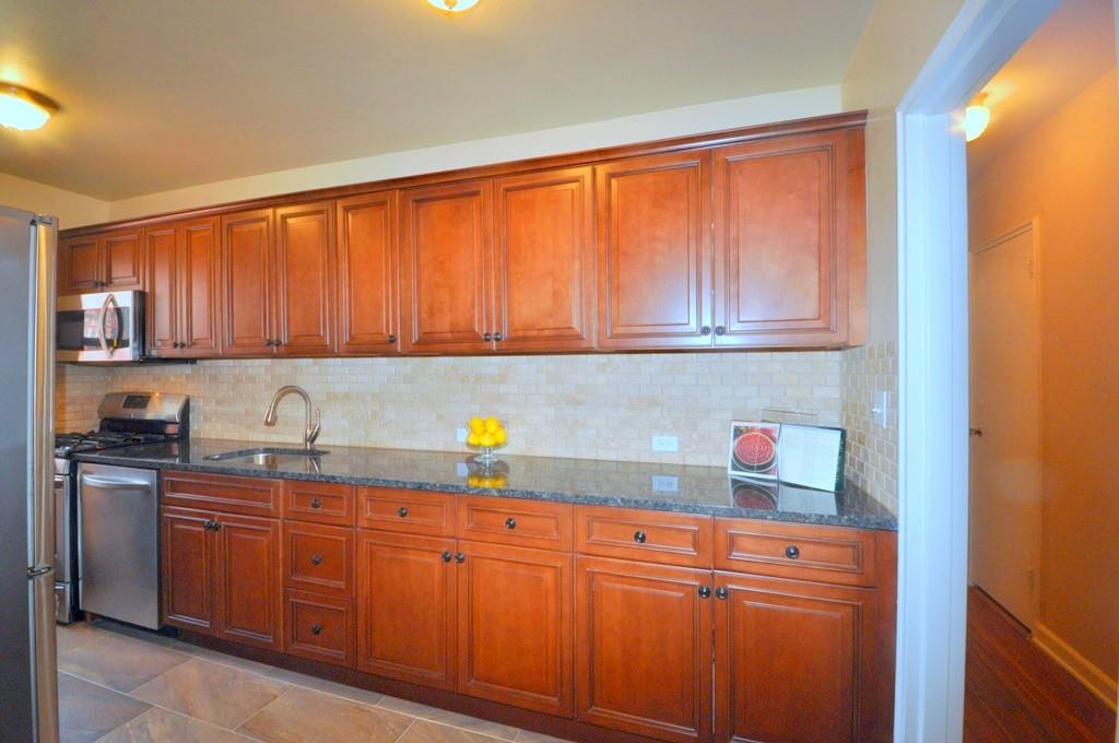 a kitchen with granite countertop wooden cabinets and sink