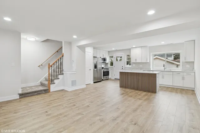 a large kitchen with a lot of counter space and wooden floor