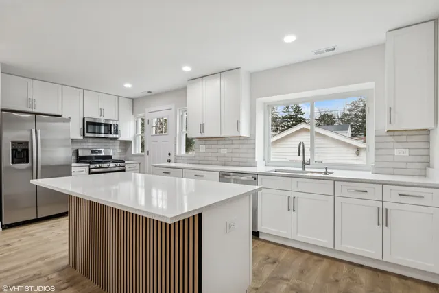 a kitchen with stainless steel appliances granite countertop a sink stove and refrigerator