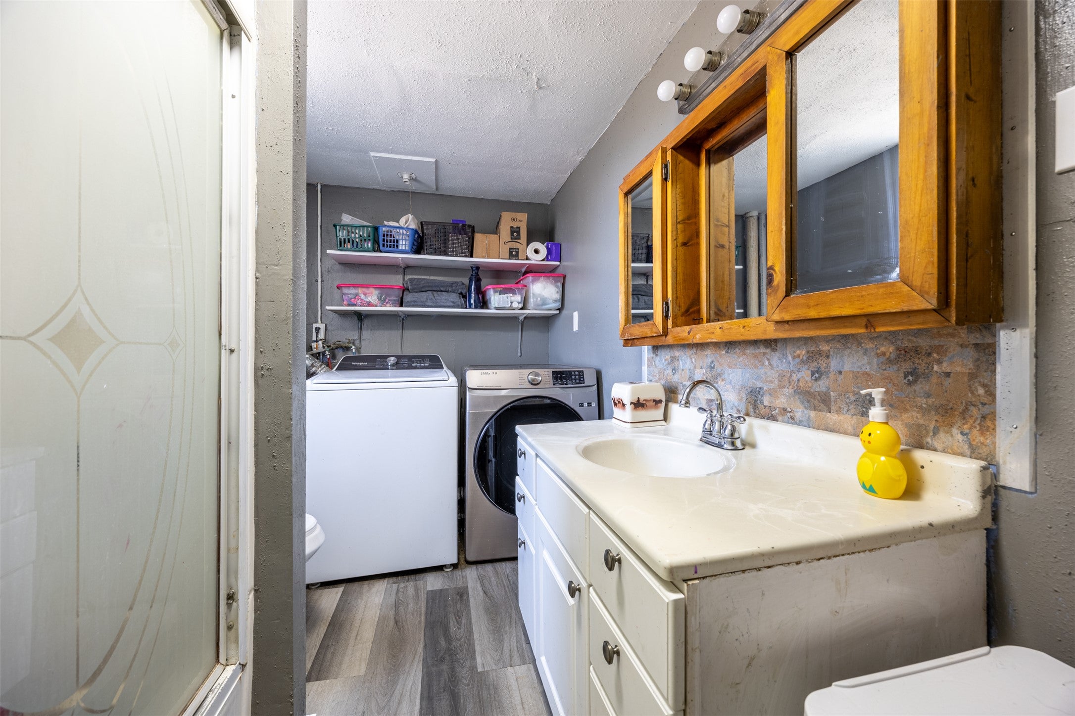 504 North Cable Road Anaconda, MT 59711 - Photo 25 of 34 Laundry room with a textured ceiling, a sink, light wood finished floors, washing machine and dryer, and laundry area