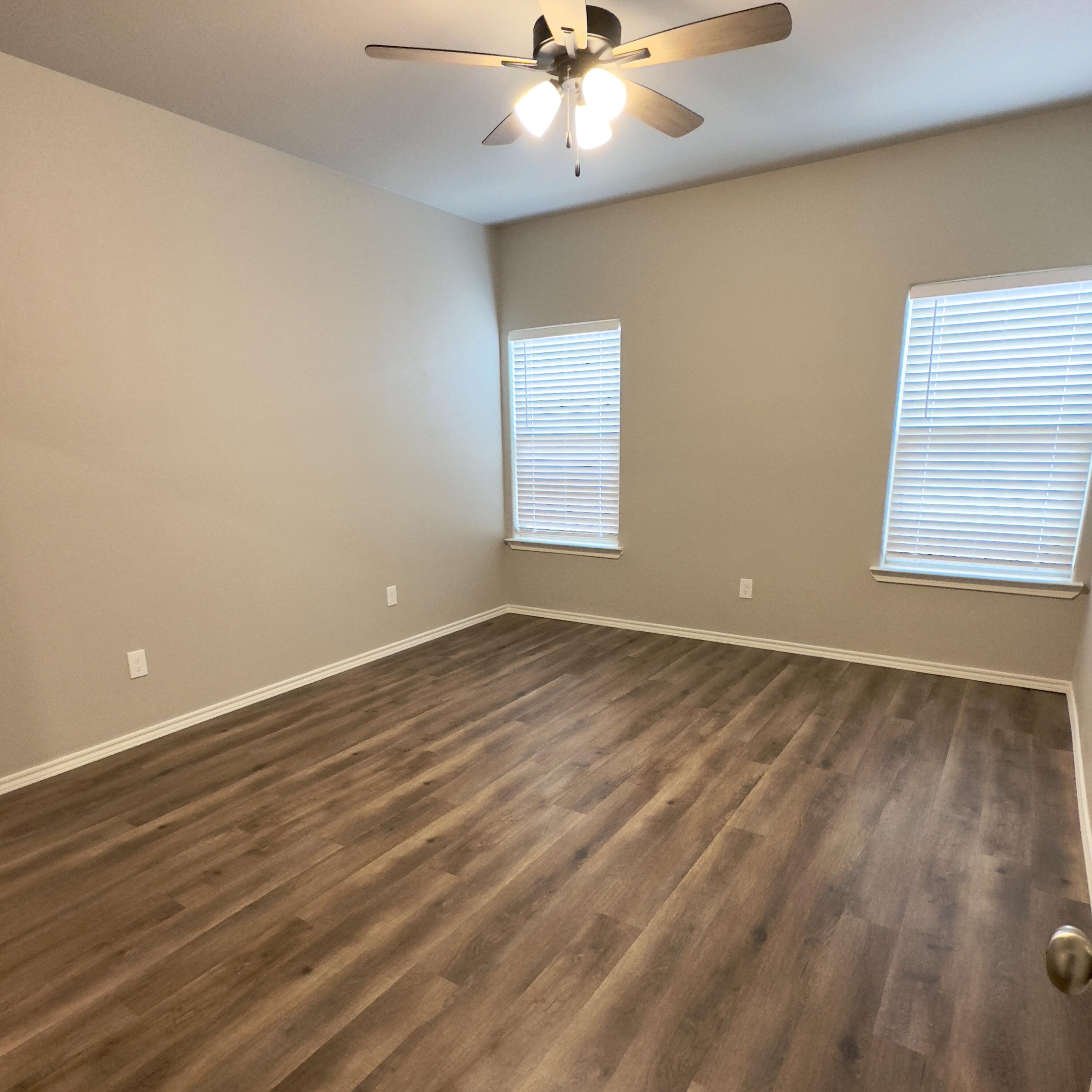 1225 Preston Trail, Unit A Wolfforth, TX 79382 - Photo 12 of 16 wooden floor in an empty room with a window