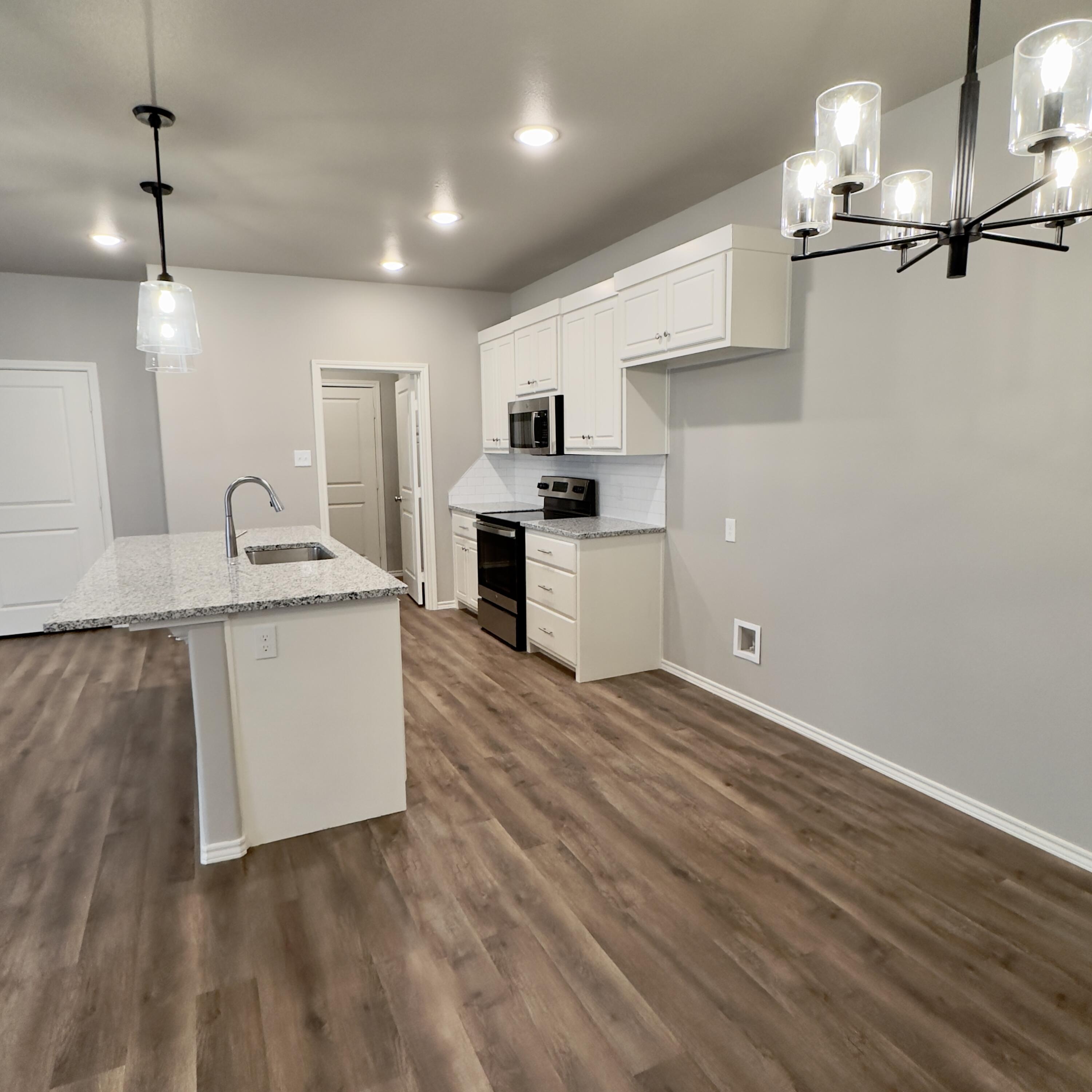 1225 Preston Trail, Unit A Wolfforth, TX 79382 - Photo 4 of 16 a kitchen with stainless steel appliances granite countertop a sink stove and refrigerator