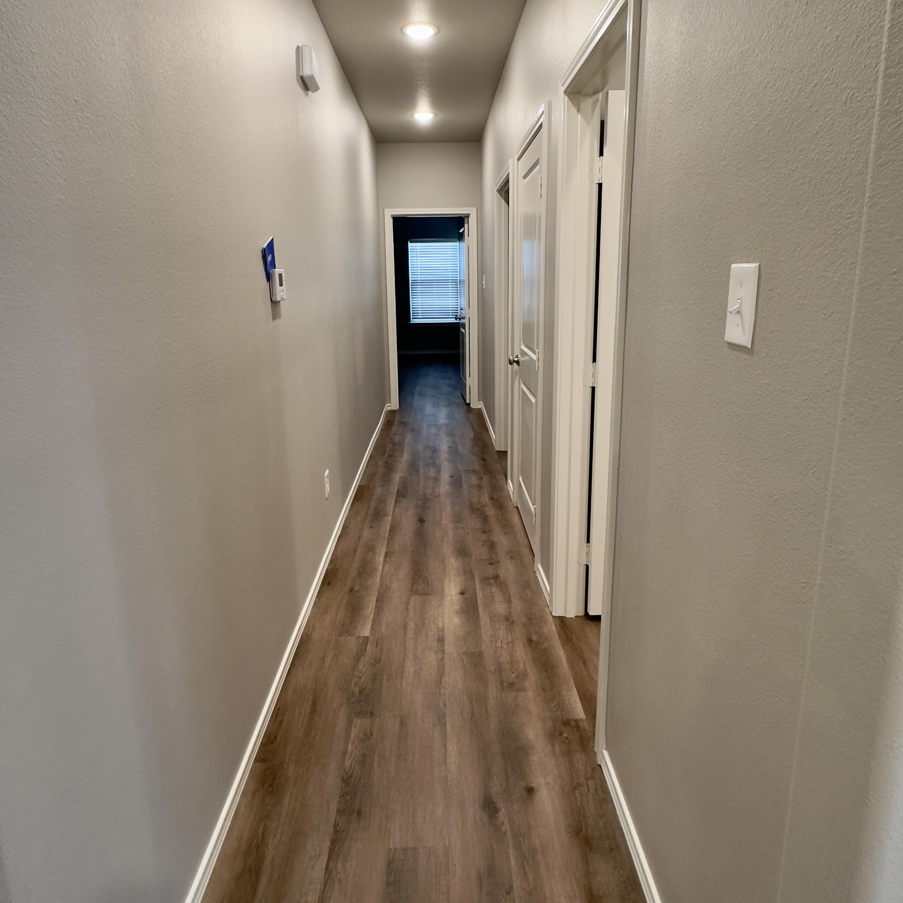 1225 Preston Trail, Unit A Wolfforth, TX 79382 - Photo 6 of 16 a view of a hallway with wooden floor and staircase