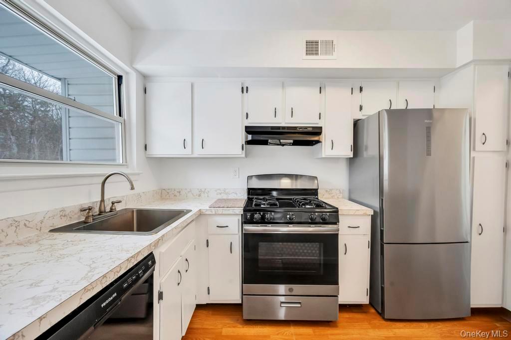 85 Rocky Point Yaphank Road, Unit 168 Rocky Point, NY 11778 - Photo 19 of 32 a kitchen with appliances a sink and cabinets
