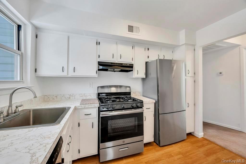 85 Rocky Point Yaphank Road, Unit 168 Rocky Point, NY 11778 - Photo 20 of 32 a kitchen with refrigerator a stove a sink and cabinets
