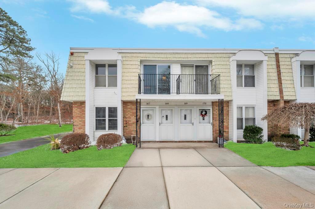 85 Rocky Point Yaphank Road, Unit 168 Rocky Point, NY 11778 - Photo 2 of 32 a view of a white house with a yard and plants