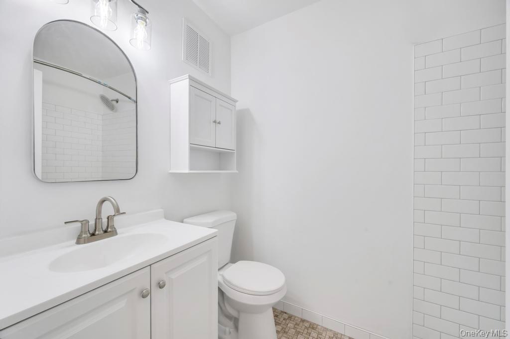 85 Rocky Point Yaphank Road, Unit 168 Rocky Point, NY 11778 - Photo 22 of 32 a bathroom with a toilet sink and mirror
