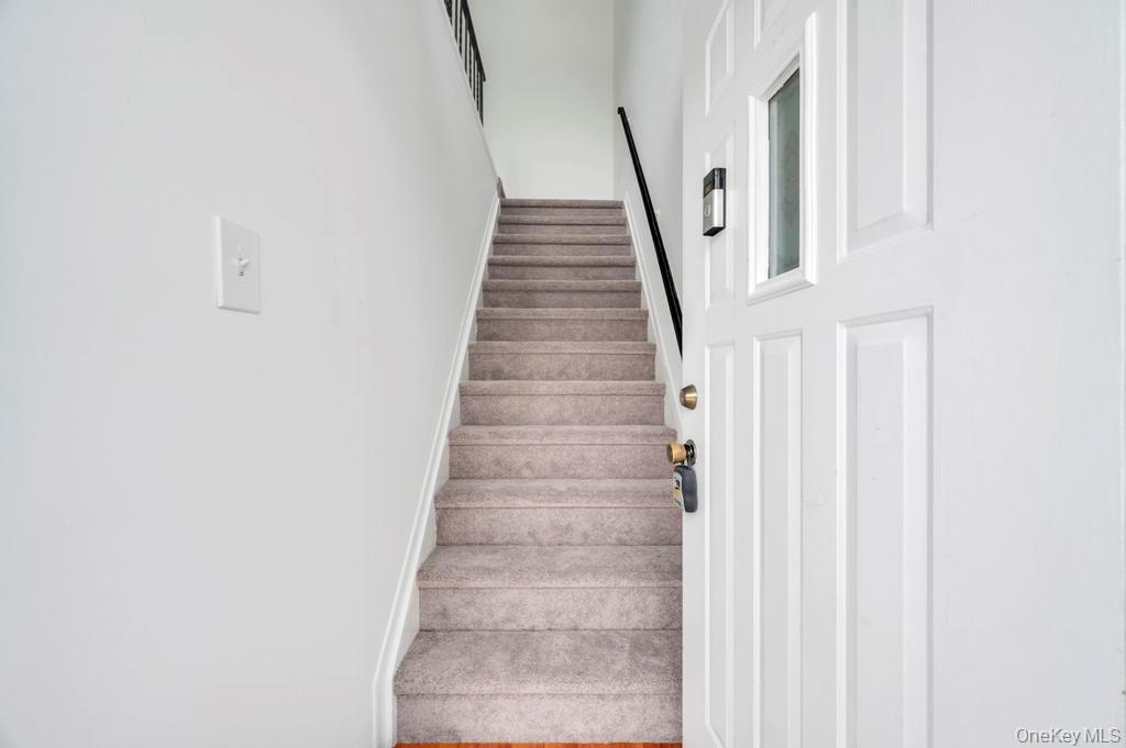 85 Rocky Point Yaphank Road, Unit 168 Rocky Point, NY 11778 - Photo 6 of 32 a view of staircase with white walls and white door