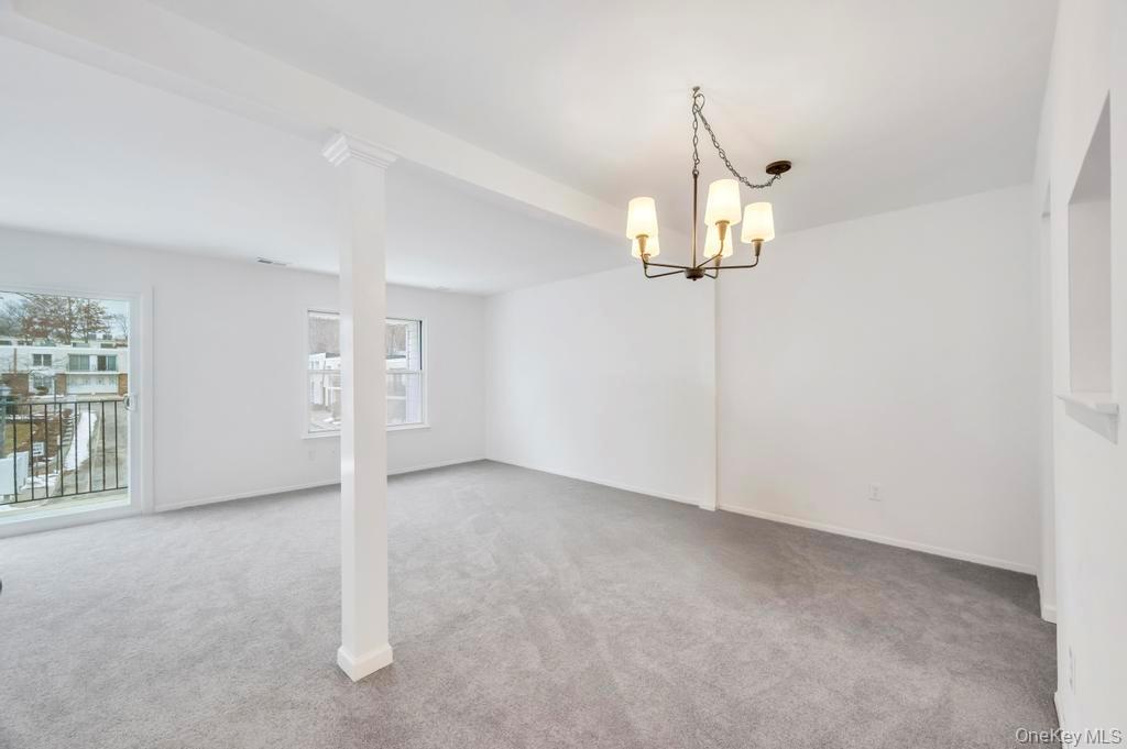 85 Rocky Point Yaphank Road, Unit 168 Rocky Point, NY 11778 - Photo 7 of 32 an empty room with chandelier fan and windows