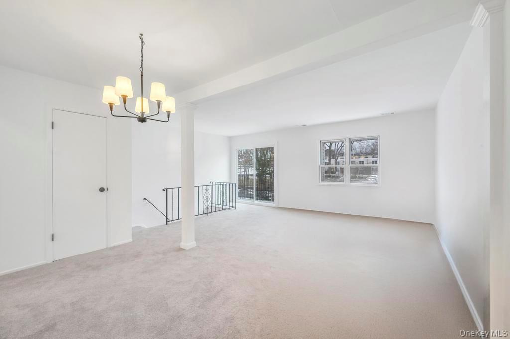 85 Rocky Point Yaphank Road, Unit 168 Rocky Point, NY 11778 - Photo 9 of 32 en empty room with windows and chandelier