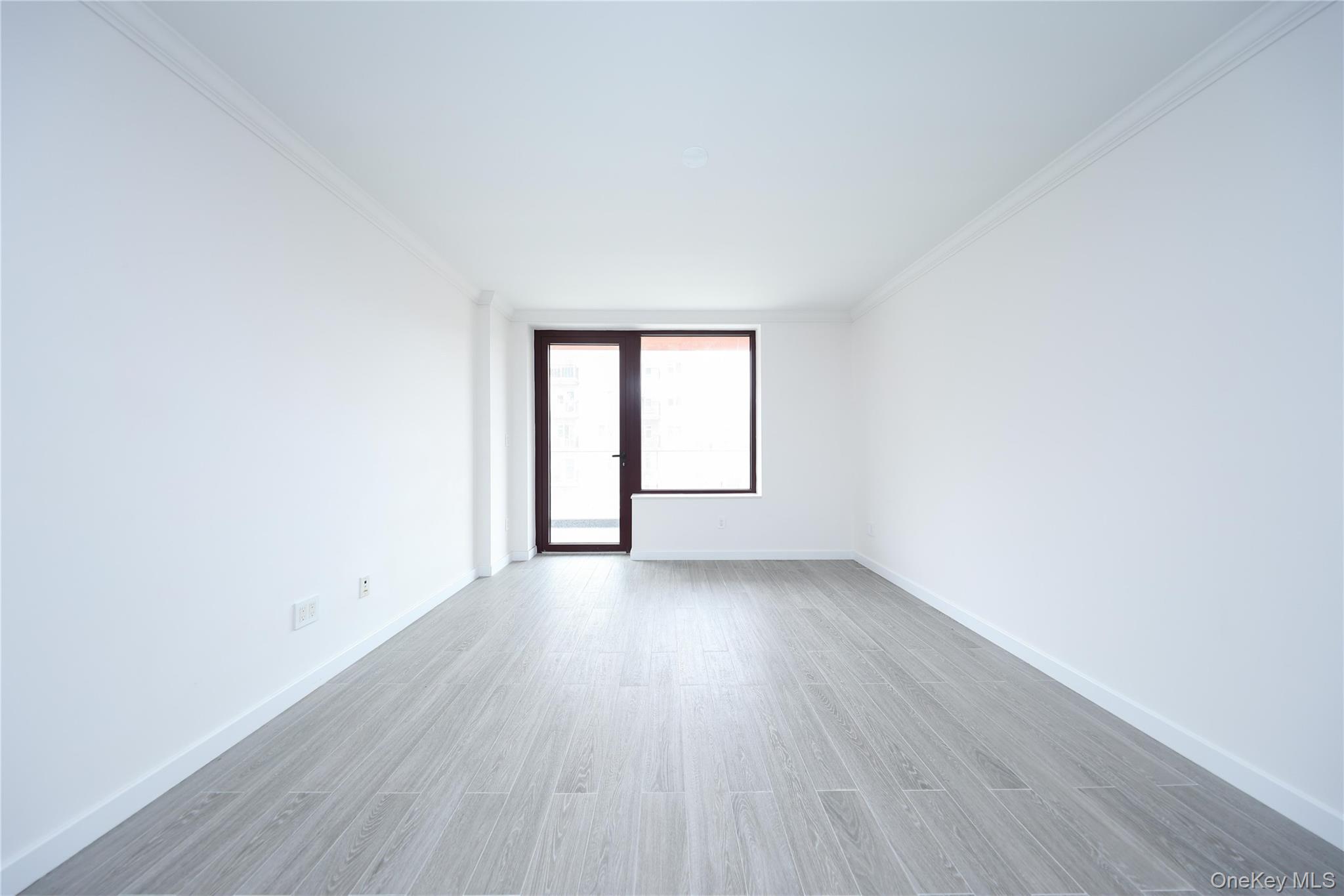 132-27 41st Road, Unit 4A Queens, NY 11355 - Photo 11 of 17 Spare room featuring crown molding and light wood-style flooring