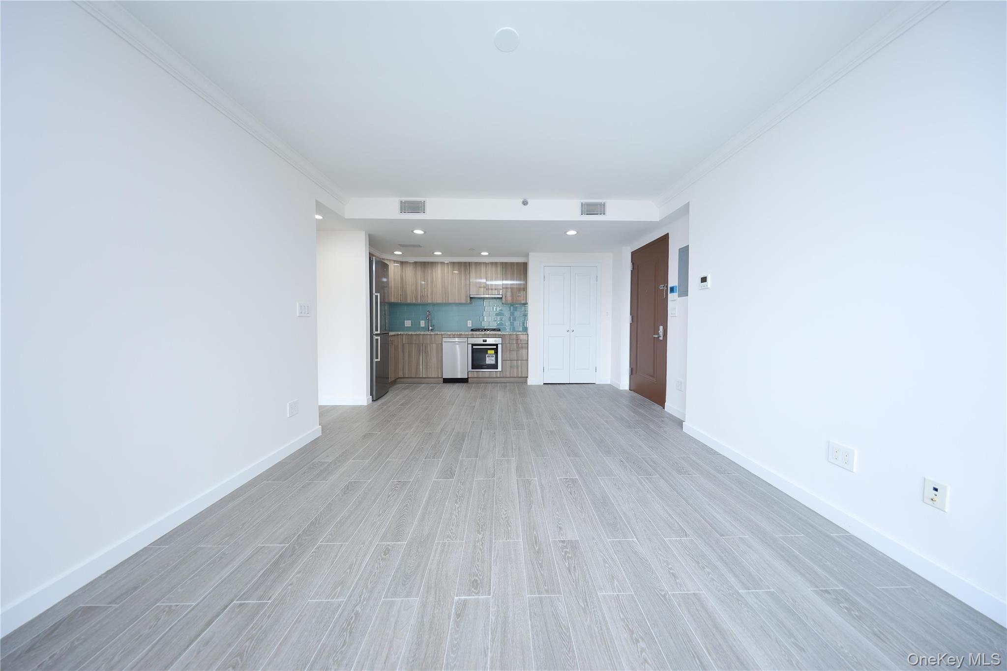 132-27 41st Road, Unit 4A Queens, NY 11355 - Photo 5 of 17 Unfurnished living room with crown molding, wood finish floors, and recessed lighting