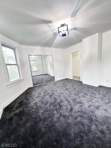 en empty room with windows and ceiling fan