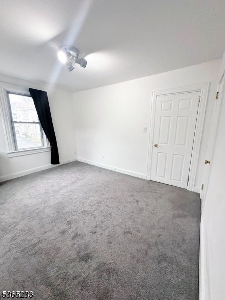 53 Hille Place, Unit 2 Ridgefield Park, NJ 07660 - Photo 4 of 9 an empty room with windows and fan