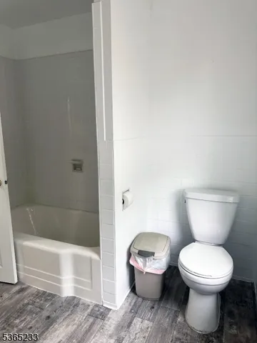 a white toilet sitting next to a bath tub