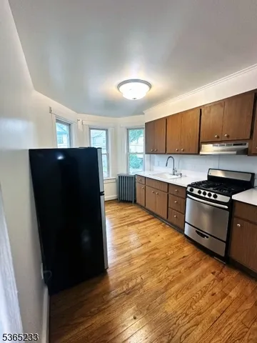 a kitchen with stainless steel appliances granite countertop a refrigerator and a stove top oven