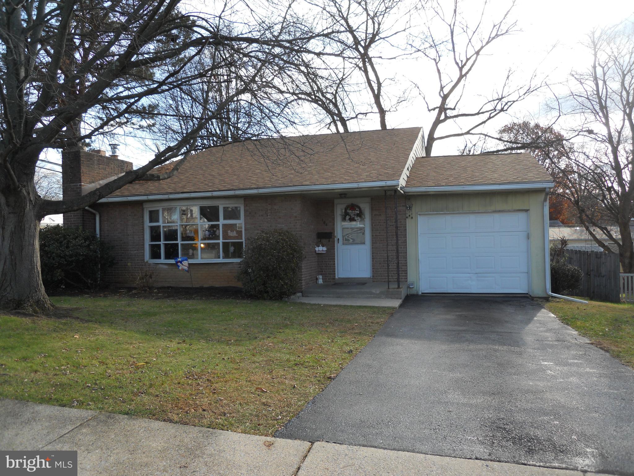 a front view of a house with a garden and trees