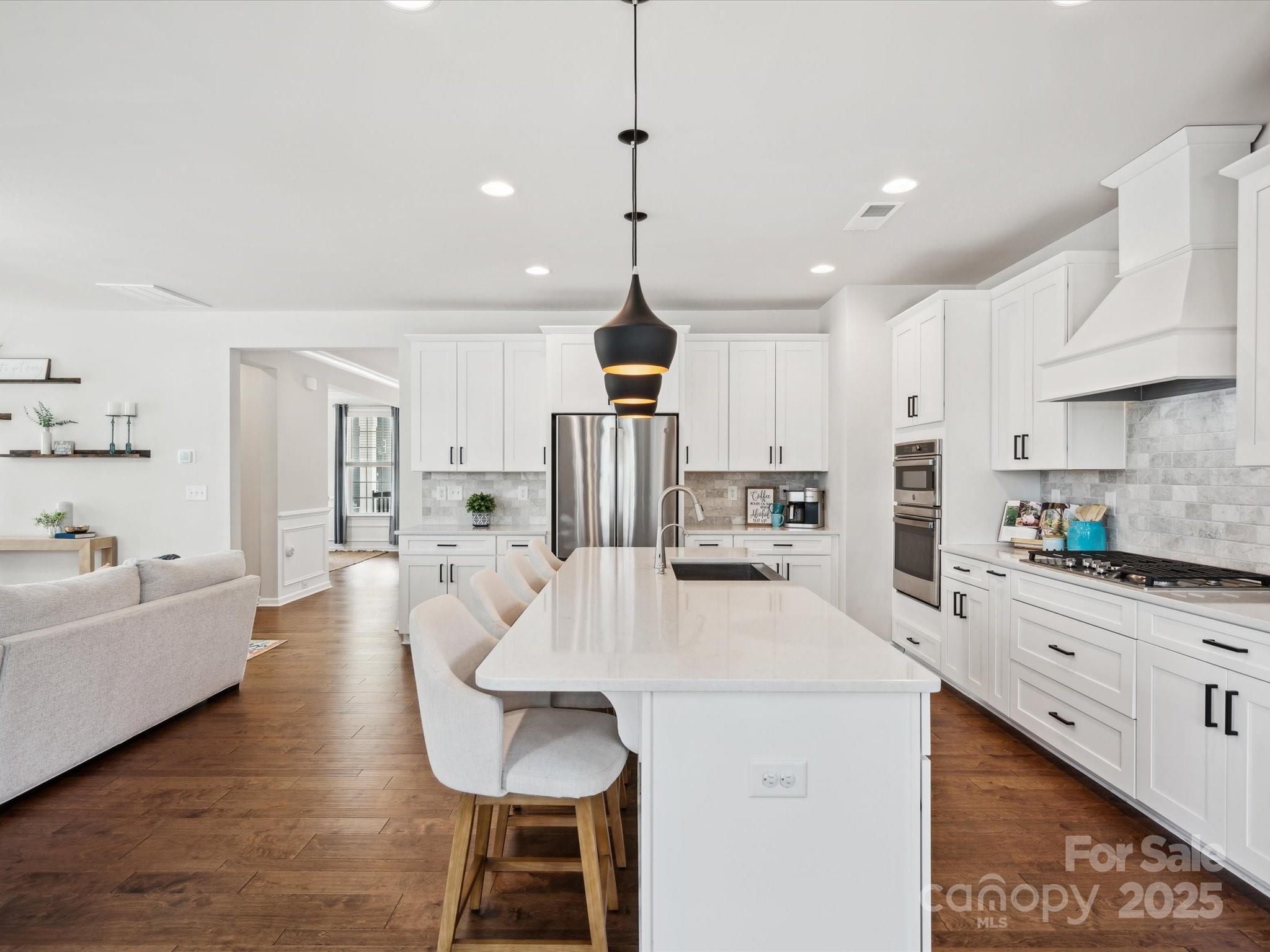 924 Stebbins Drive Fort Mill, SC 29715 - Photo 14 of 48 a kitchen with stainless steel appliances kitchen island granite countertop a sink a stove a refrigerator and white cabinets
