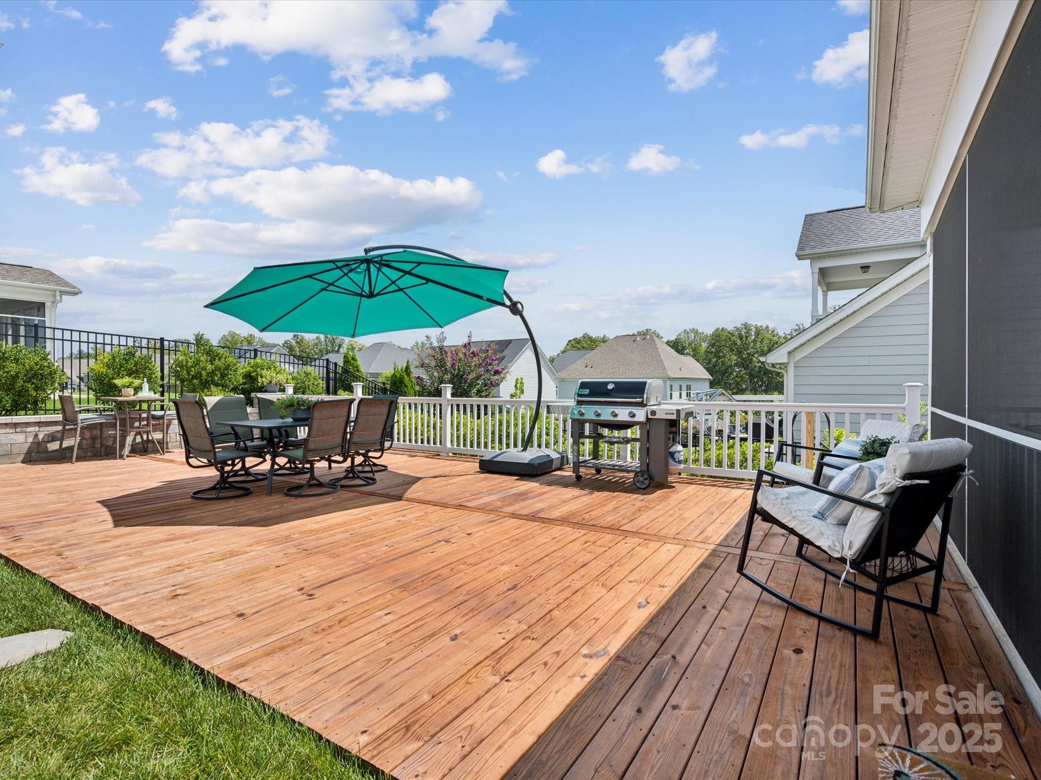 924 Stebbins Drive Fort Mill, SC 29715 - Photo 36 of 48 a view of a patio with a dining table and chairs under an umbrella with a barbeque