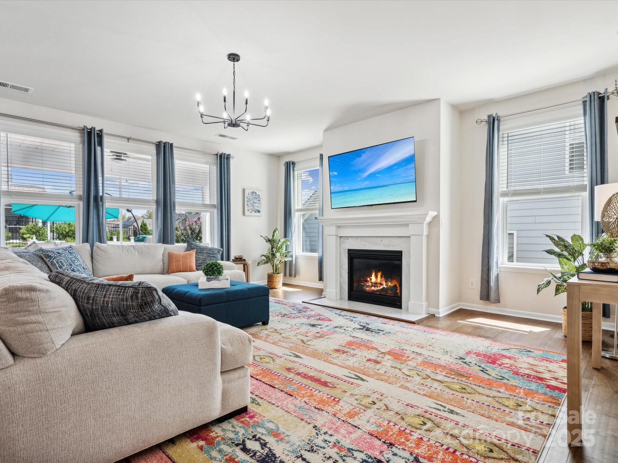 924 Stebbins Drive Fort Mill, SC 29715 - Photo 10 of 48 a living room with furniture a chandelier and a fireplace
