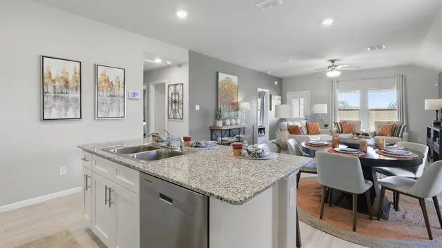 a kitchen with stainless steel appliances granite countertop a stove a sink and a refrigerator