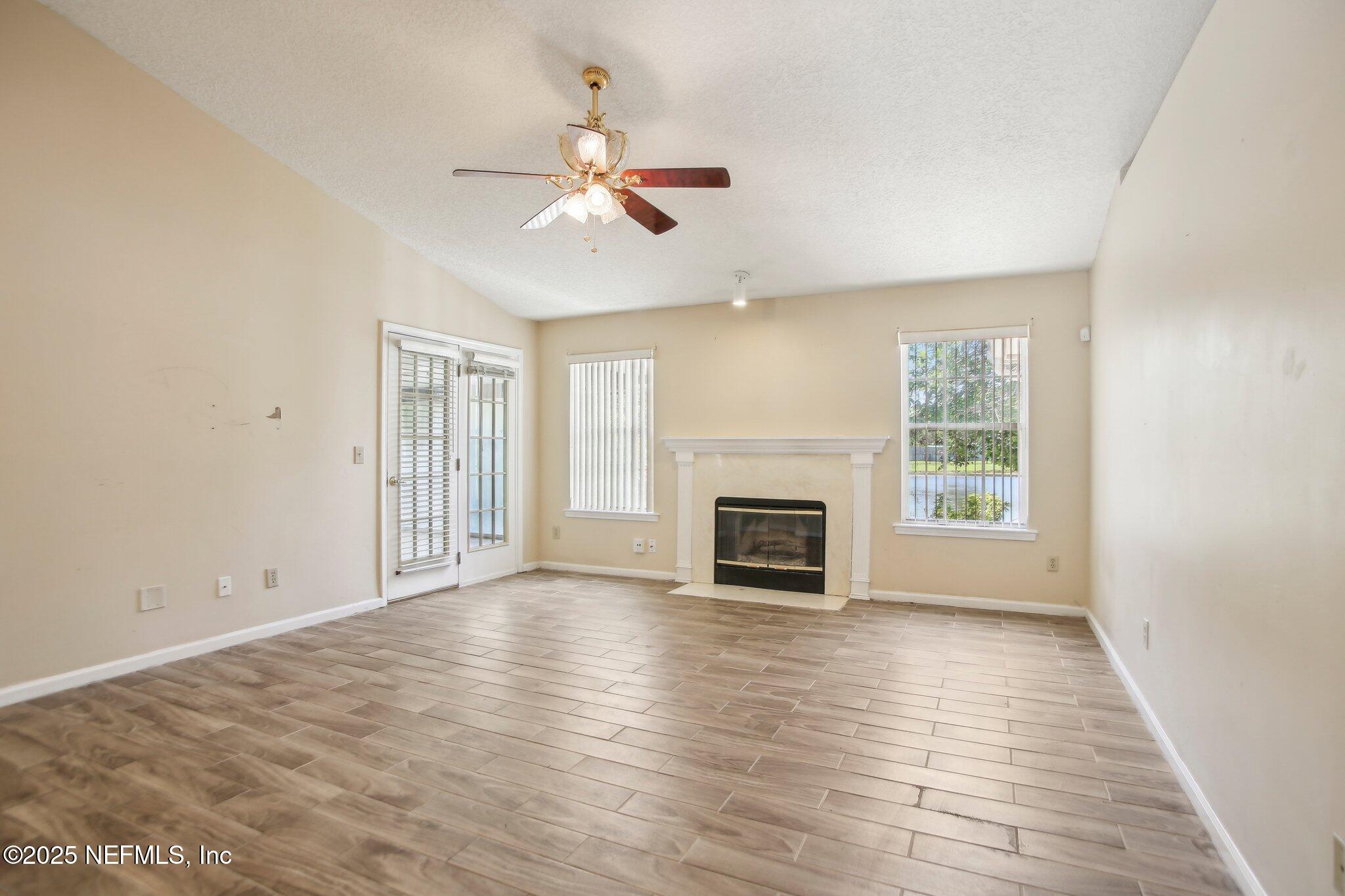 1634 Dockside Drive Fleming Island, FL 32003 - Photo 15 of 44 an empty room with wooden floor fan and windows