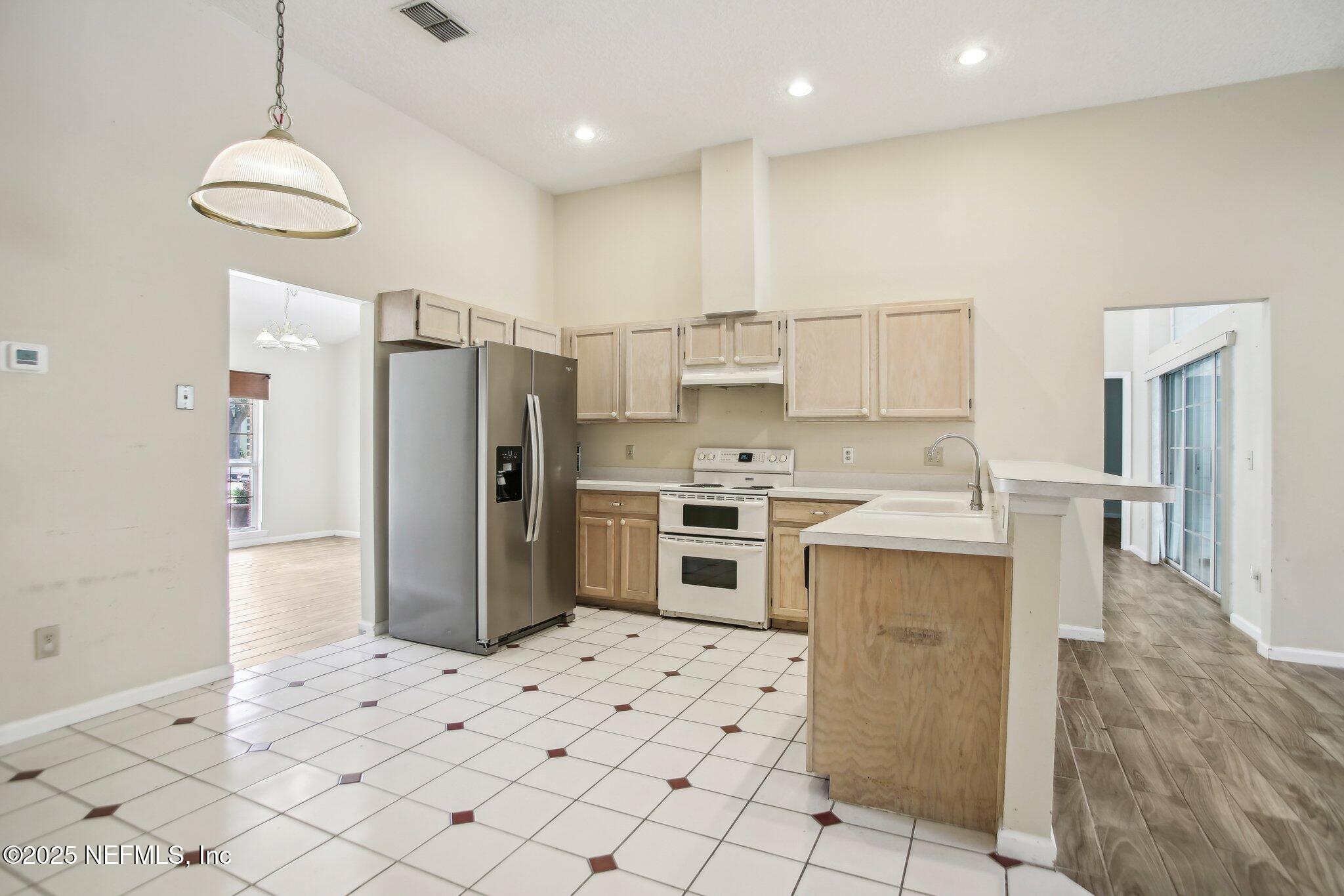 1634 Dockside Drive Fleming Island, FL 32003 - Photo 18 of 44 a kitchen with a refrigerator a oven and a sink with wooden floor