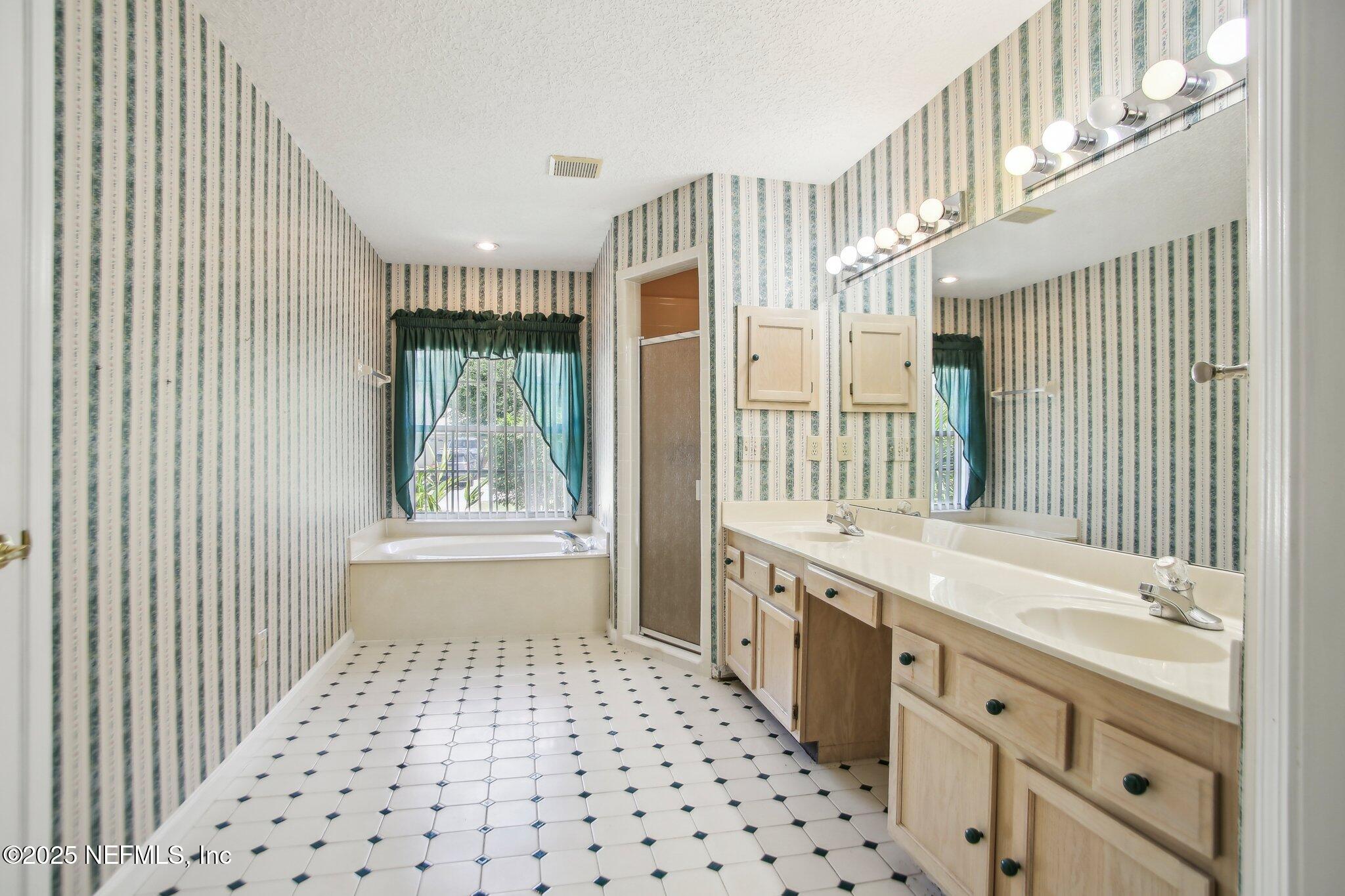 1634 Dockside Drive Fleming Island, FL 32003 - Photo 24 of 44 a bathroom with a double vanity sink a mirror and a bathtub