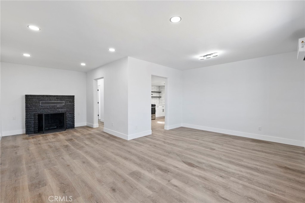 25441 Main Street Barstow, CA 92311 - Photo 11 of 66 a view of an empty room with wooden floor fireplace and a window