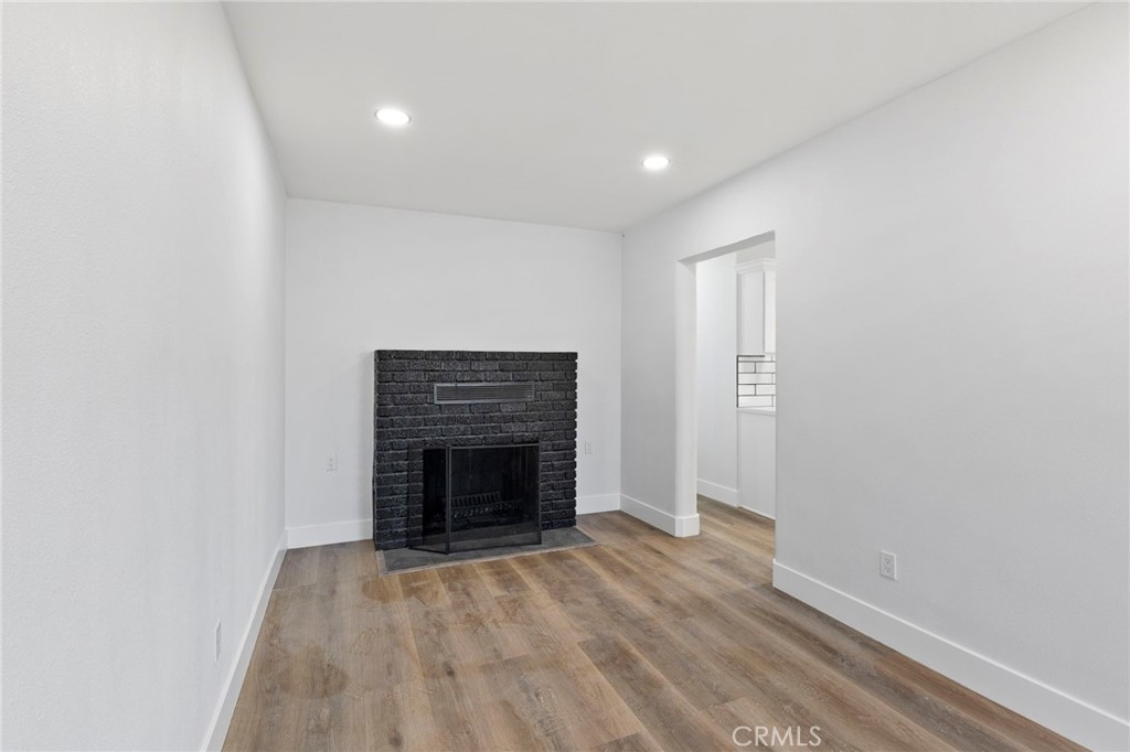 25441 Main Street Barstow, CA 92311 - Photo 12 of 66 a view of an empty room with wooden floor fireplace and a window