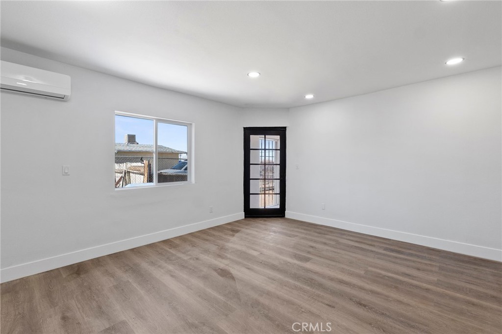 25441 Main Street Barstow, CA 92311 - Photo 13 of 66 a view of an empty room with a window and wooden floor